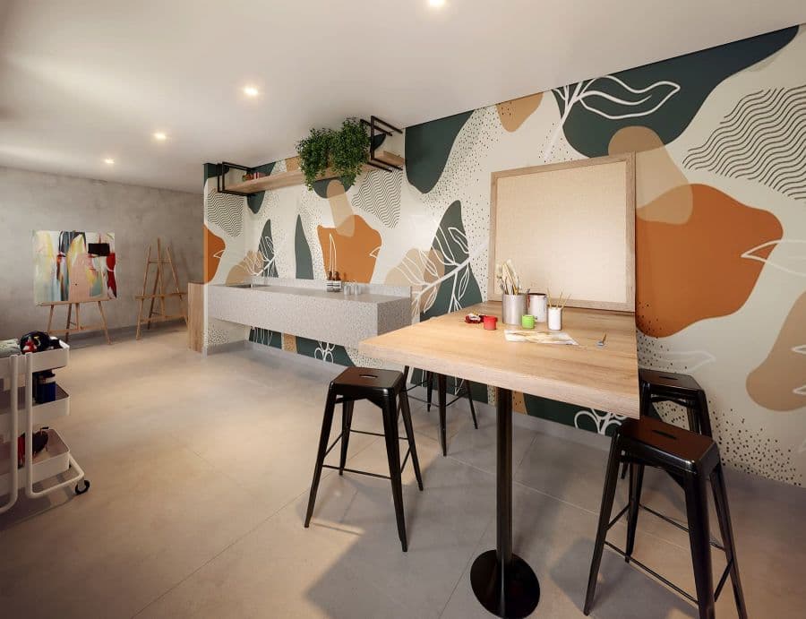 Ateliê de artes com mesa alta, banquetas e cavaletes de pintura