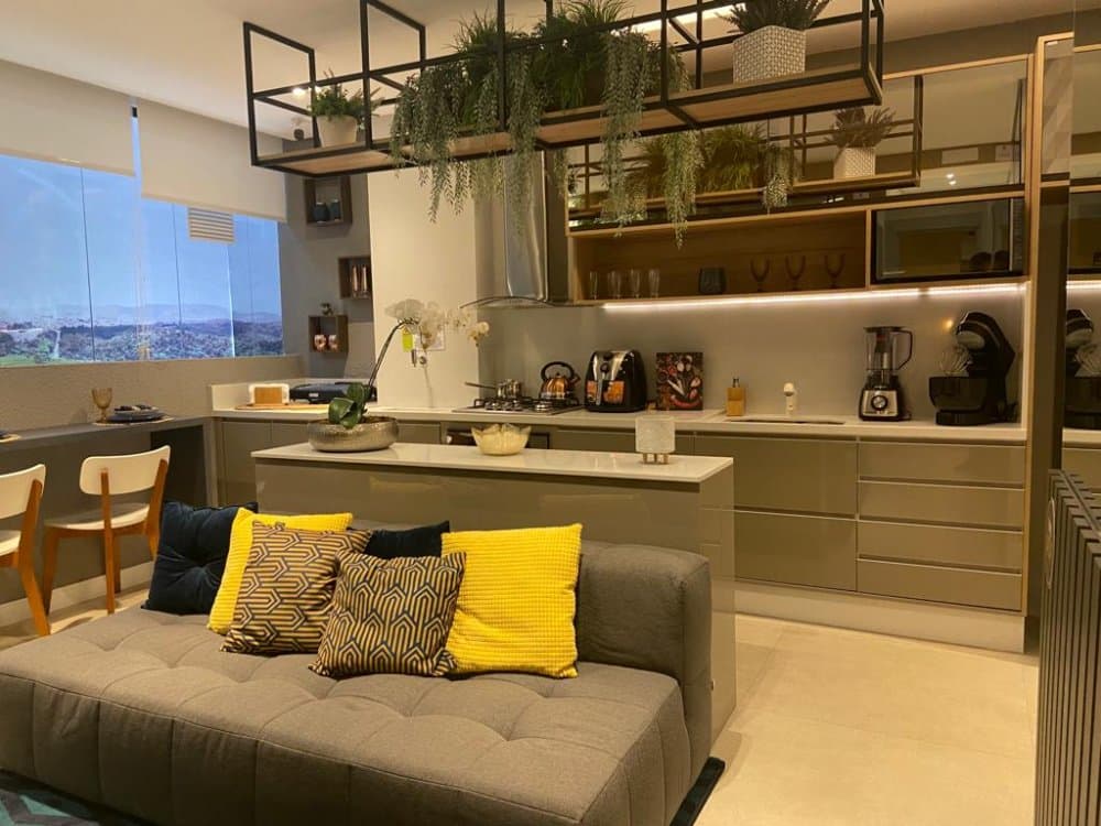 Cozinha americana com bancada e armários integrada ao living