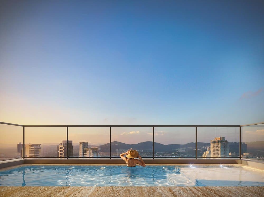 Piscina no rooftop com vista panorâmica da cidade ao entardecer